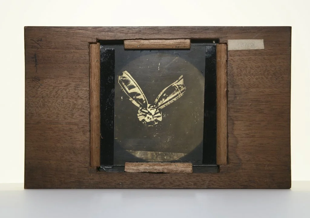 Sutton's blue-violet-filter lantern slide of a tartan ribbon, in a wooden frame